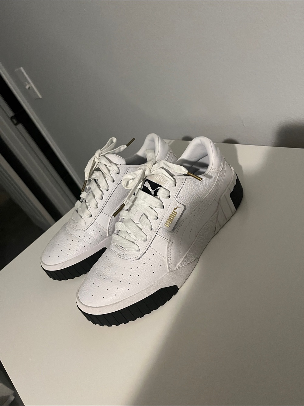 Puma White Low-Top Sneakers with Black Outsole and Gold Accents